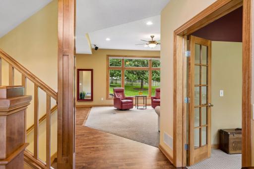 The welcoming entry with rich woodwork, offering a glimpse of the open floor plan, oversized windows, and thoughtfully designed living spaces and beyond.