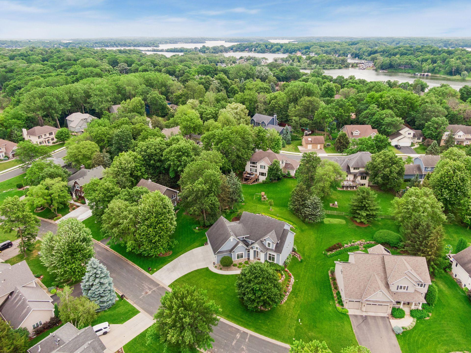 From above, the homes exceptional setting comes into focus - nestled among mature trees on a picturesque lot in Saunders Lake, just minutes from Lake Minnetonka and the Dakota Rail Regional Trail