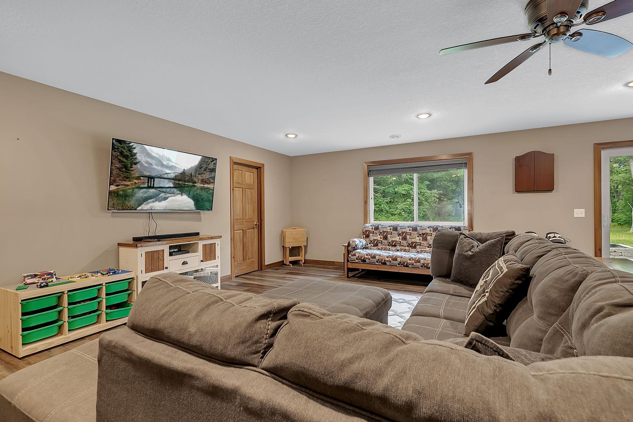The finished walkout lower level provides additional living space with a spacious family room, bedrooms, bathroom, and access to the patio and fire pit area.