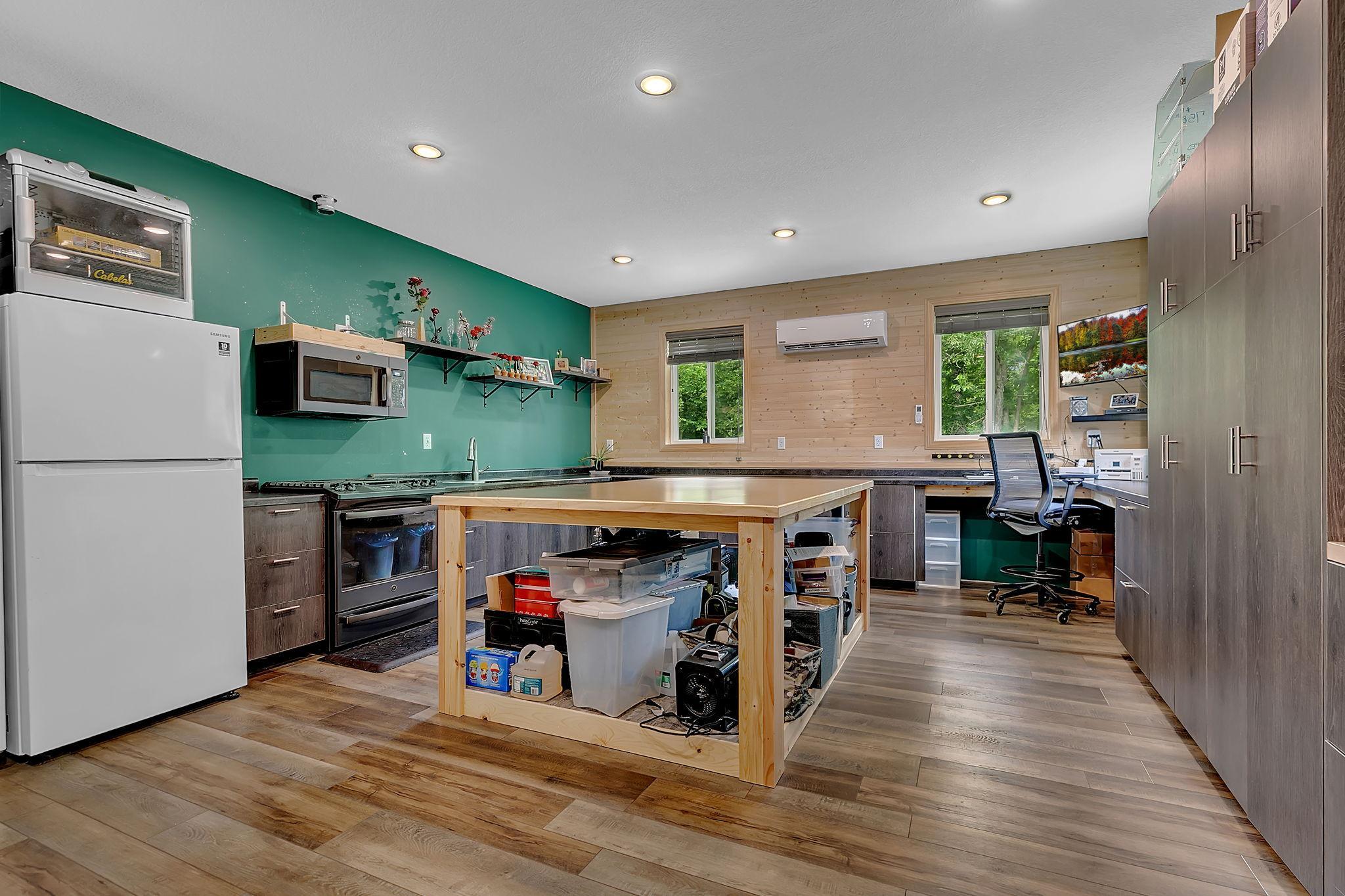 A 2025 addition located behind the attached garage adds exceptional flexibility with in-floor heat and a ductless mini-split system, making it ideal for a home office, workshop, fitness area, recreation room, or hobby space.