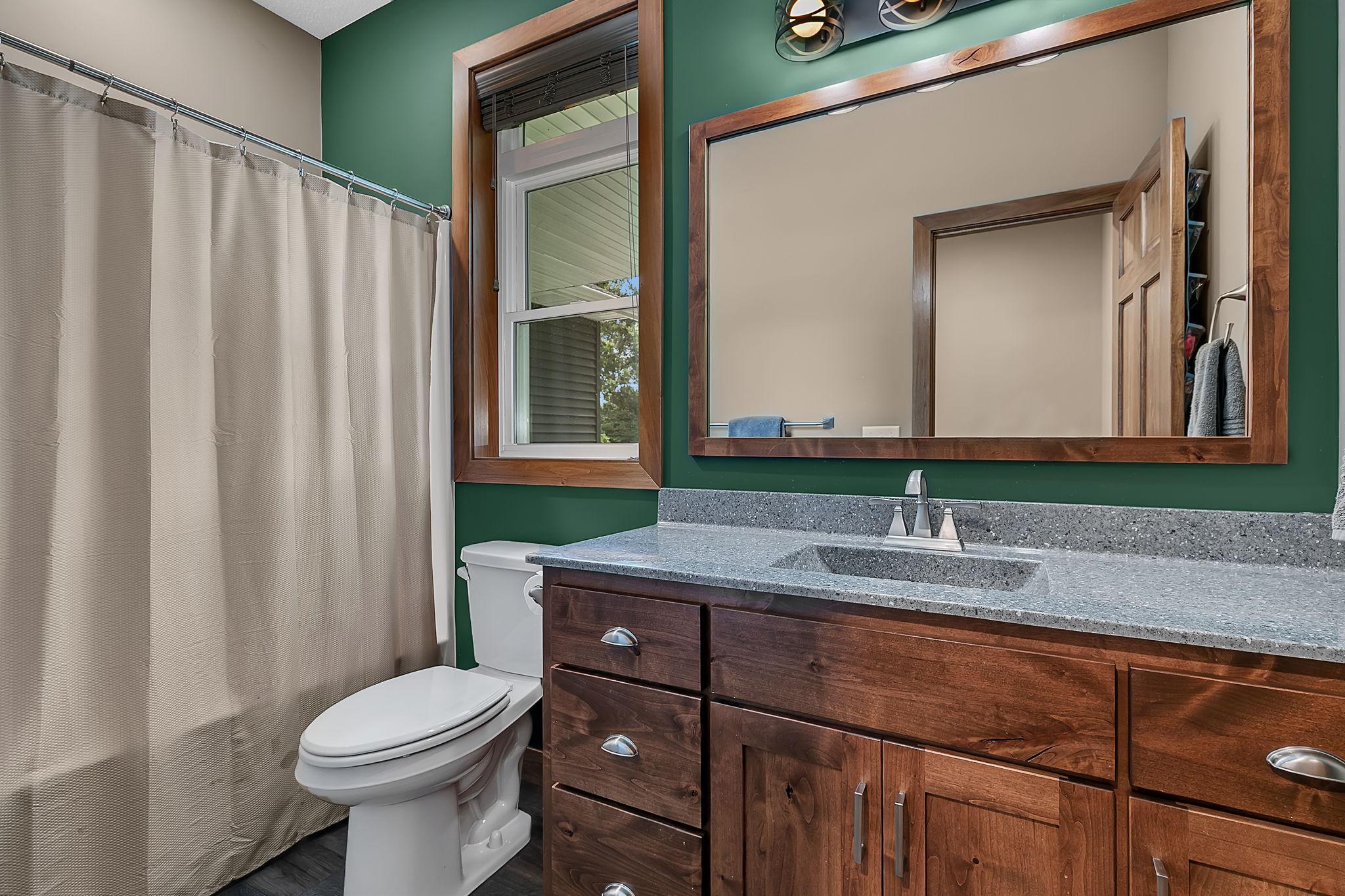 Thoughtfully located on the main level, the full guest bathroom offers a large vanity, plentiful storage, and a tub/shower combination.