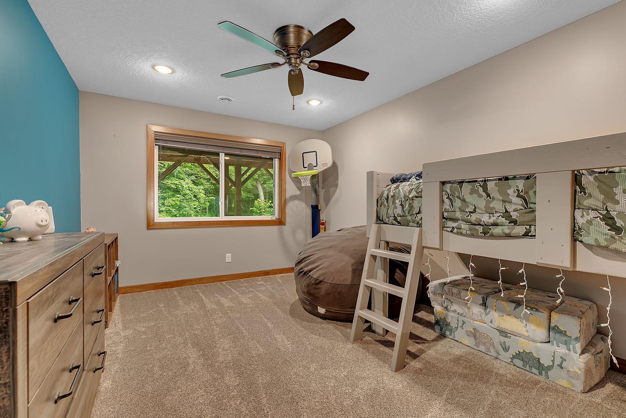 Perfect for growing families or overnight guests, one of two lower-level bedrooms offers a comfortable retreat with peaceful wooded views just outside the window.