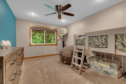 Perfect for growing families or overnight guests, one of two lower-level bedrooms offers a comfortable retreat with peaceful wooded views just outside the window.