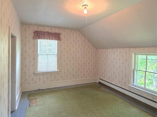Offering classic farmhouse charm, this upper-level bedroom features angled ceilings, abundant natural light, and peaceful views.