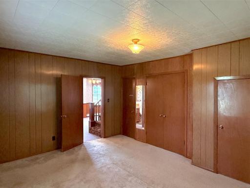 Warm wood-paneled walls create a cozy country feel, while multiple closets offer great storage space.