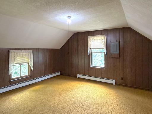 Tucked beneath the roofline, this spacious upper-level bedroom offers a cozy retreat with charming angled ceilings.