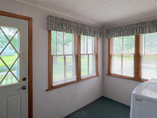 This bright and versatile porch doubles as a convenient laundry area, surrounded by windows with a view.