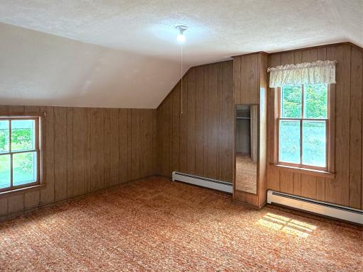 Upper-level bedroom offers a spacious layout, while the cozy setting creates a comfortable retreat for family or guests.