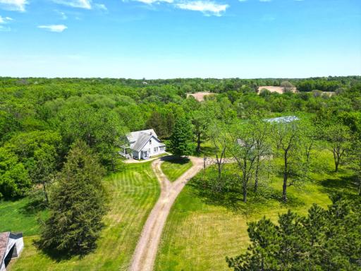Surrounded by nature and complemented by nearby outbuildings, this timeless home captures the essence of rural living along scenic Plum Creek.