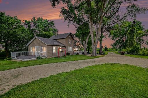 Twilight exterior of the updated New Prague farmhouse on 4.82 acres, golden-hour curb appeal