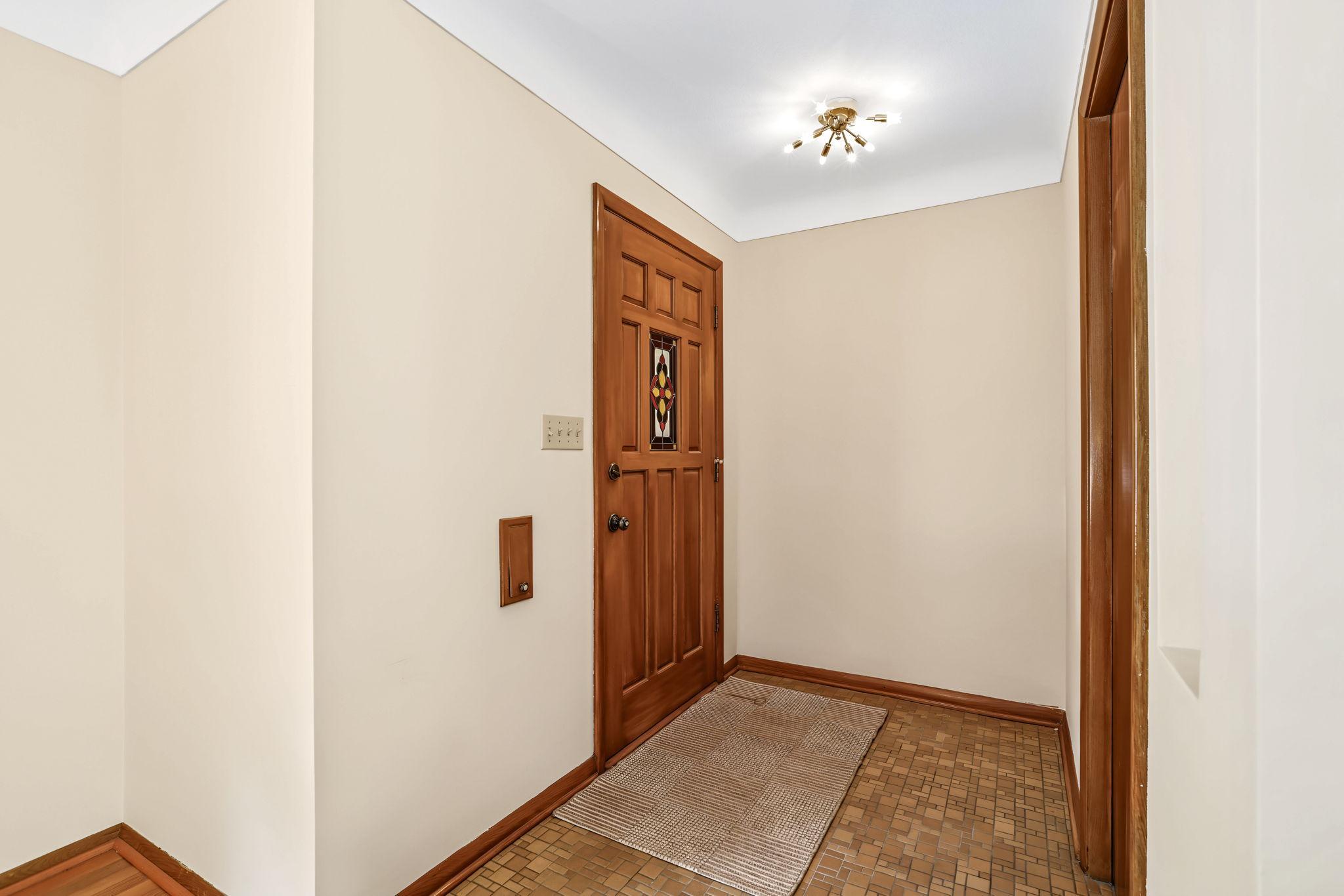 Spacious entry area features a stained glass window and adorable original light fixture.