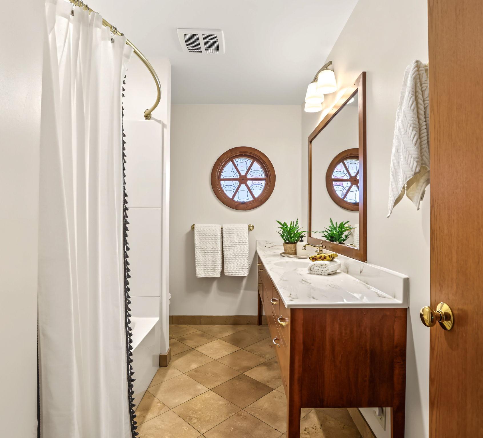 Main level full bathroom with a unique circular window!