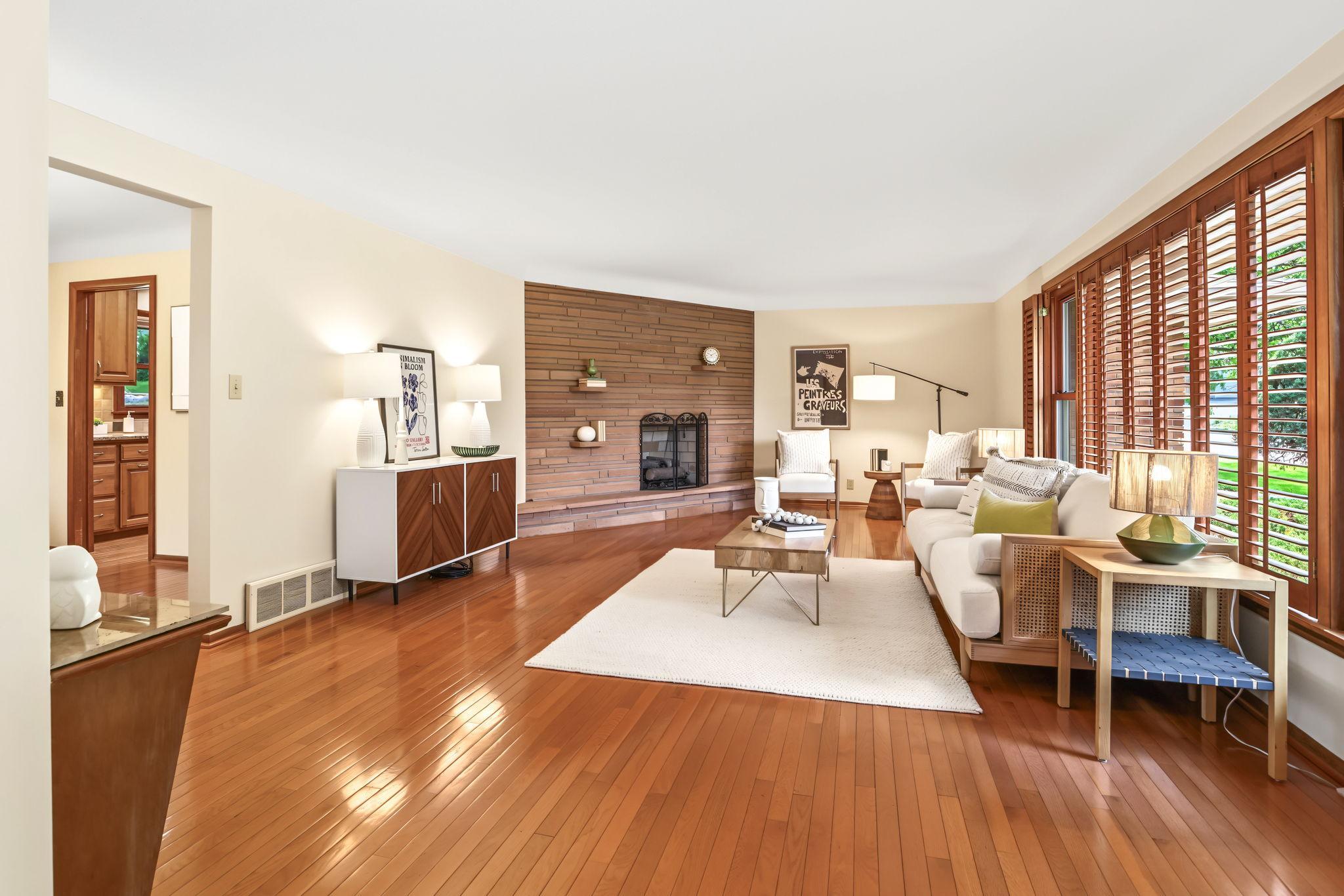 Enter into the bright living room with gorgeous hardwood floors and mid-century stone fireplace.