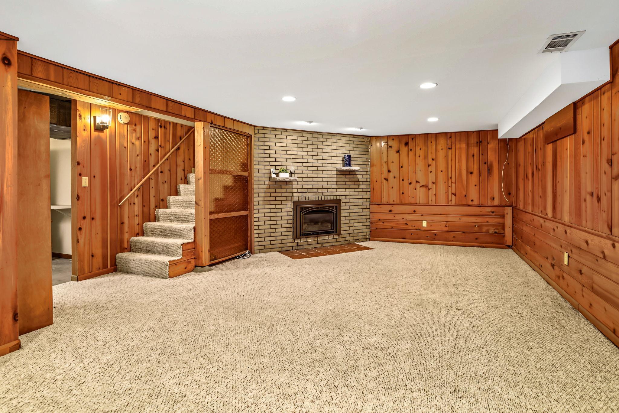Lower level family room with gorgeous woodwork and another gas fireplace.