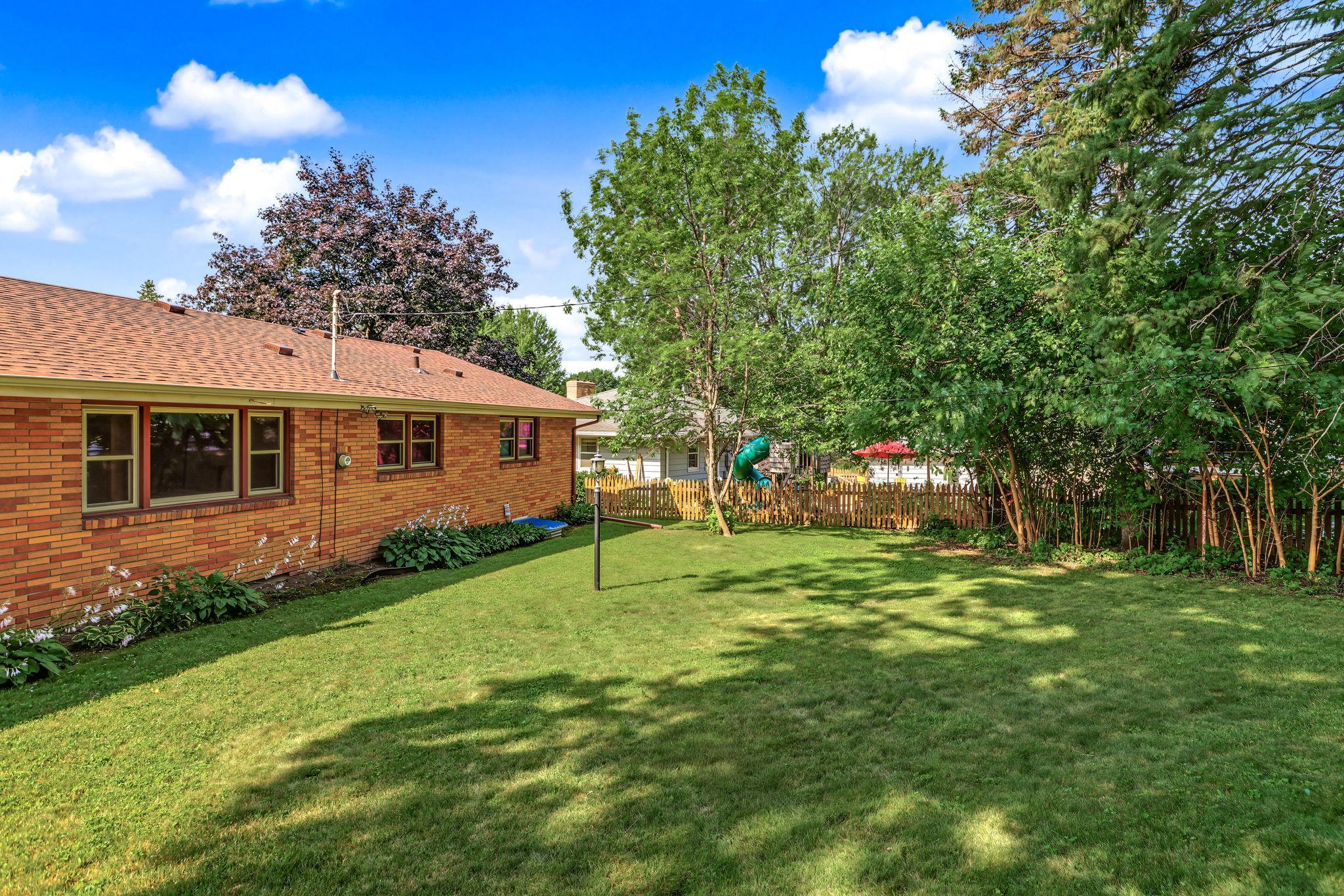 Spacious flat backyard with mature landscaping.