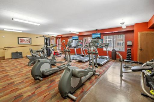 Fitness center with cardio and weight-training machines, a yoga studio, and an indoor pool