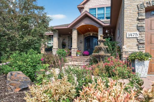 Stunning front entry with stamped concrete, gorgeous landscaping and waterfountain