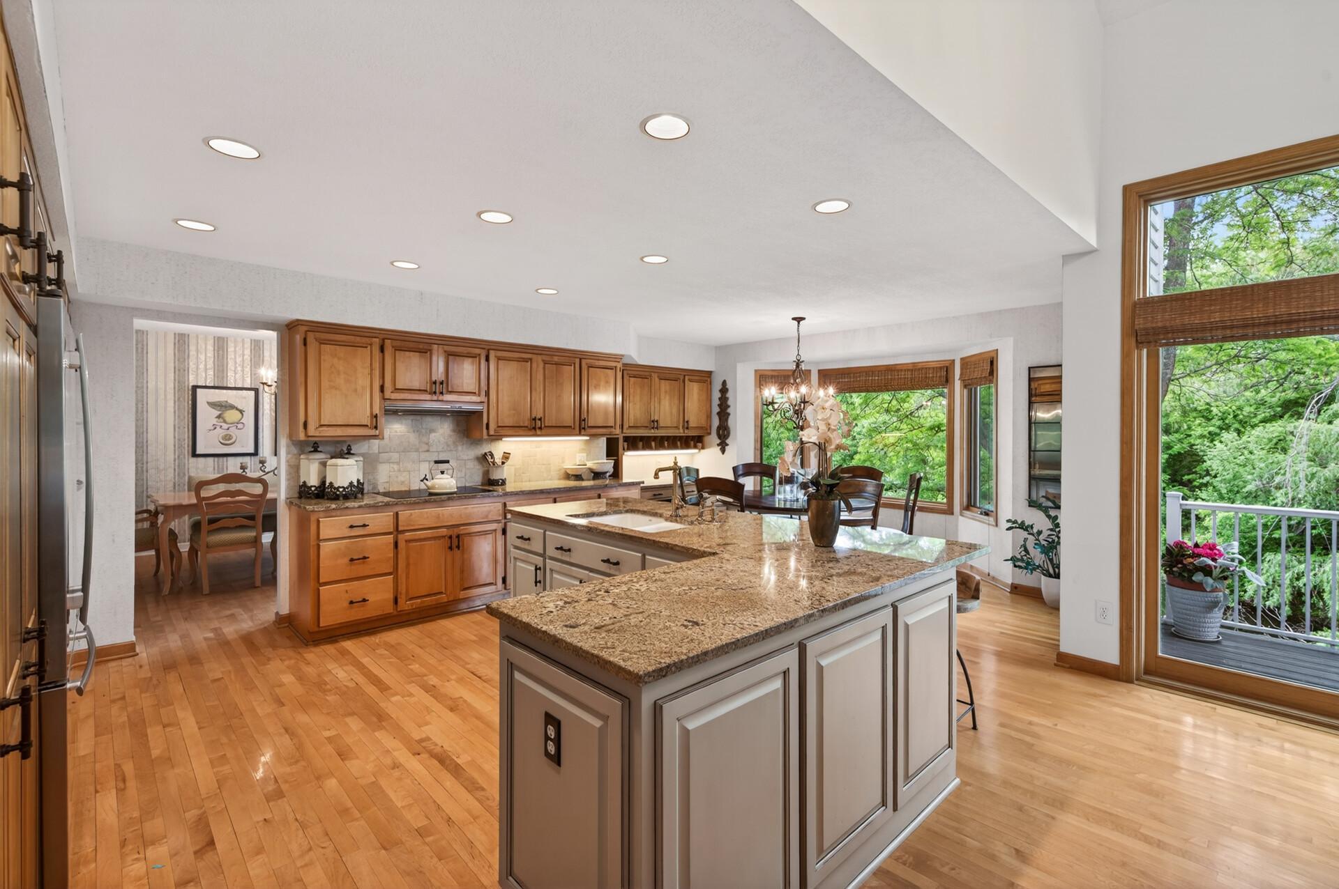 The kitchen serves as the heart of the home, offering abundant maple cabinetry, granite countertops, an oversized center island with breakfast bar.