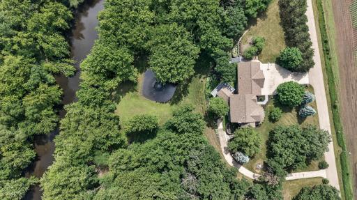 An incredible aerial perspective showcases the property's private acreage, scenic pond, and beautiful river frontage—offering a setting that's nearly impossible to replicate.