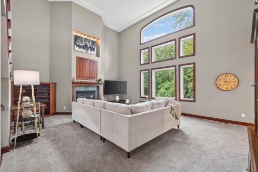 Soaring ceilings and a dramatic wall of windows fill this stunning living room with natural light.