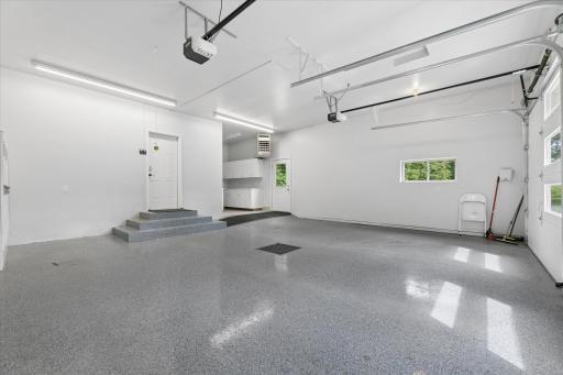 Finished, heated garage with epoxy flooring, floor drain, water, natural light, bright fluorescent lighting, doggy-door, locker system.