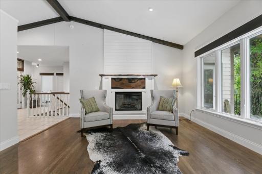 Main Level with floor to ceiling gas fireplace finished with live-edge mantle and unique wood detailing. Vaulted ceilings and hardwood floors throughout.