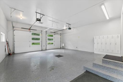 Finished, heated garage with epoxy flooring, floor drain, water, natural light, bright fluorescent lighting, doggy-door, locker system.