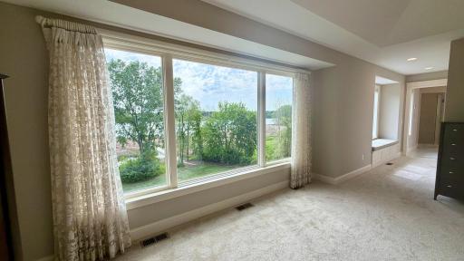 Wake up to this view every single morning! A breathtaking wall of windows perfectly frames panoramic views of the private, professionally landscaped backyard and the pristine waters of beautiful Lake Elmo.