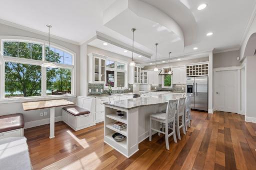 The true heart of the home! This massive kitchen offers abundant room for gathering, whether guests pull up a stool at the large center island or relax in the custom banquette benches overlooking the lake.