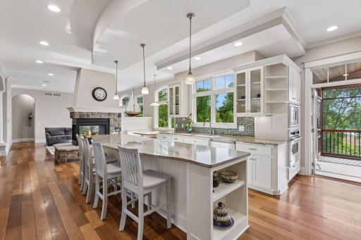 Doing dishes with a view! Two kitchen windows frame stunning lake vistas, while an adjacent door leads straight to the screened porch and outdoor built-in grill. Summer meal prep and indoor/outdoor entertaining have never been easier.
