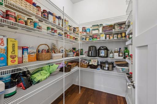 Storage galore! In addition to the abundant kitchen cabinetry, this spacious walk-in pantry features convenient built-in shelving to keep your gourmet ingredients perfectly organized.