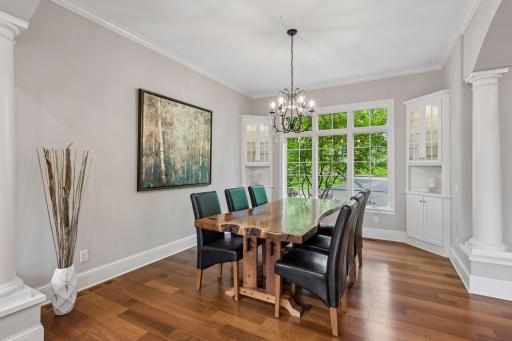 The perfect setting for family gatherings and holiday meals! This elegant formal dining room opens beautifully to the kitchen and living room, featuring crown molding, rich wood floors, and built-in corner cabinets.