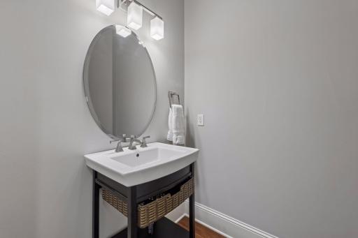 Everyday convenience: a main floor powder room located just steps from a large storage closet and the direct entry door to the north garage.
