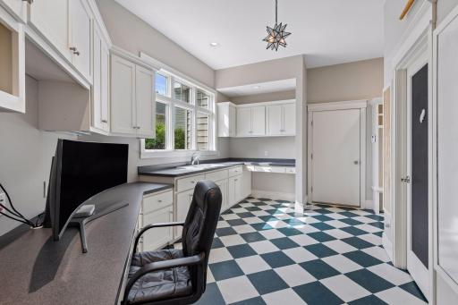 Ultimate organization hub! Just off the kitchen, this massive craft/mudroom features a built-in desk & counter with a double sink, endless cabinet storage, custom lockers & cubbies, a large storage closet, a broom closet & access to the south garage.