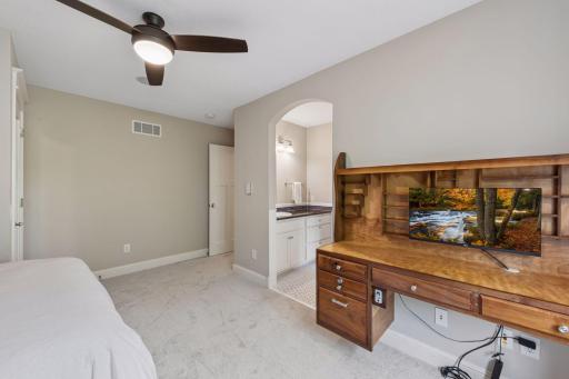 A perfect setup for kids or guests. This angle showcases the custom desk alongside access to a unique Jack & Jill bathroom design, where each bedroom enjoys the ultimate privacy of its own dedicated vanity and sink.