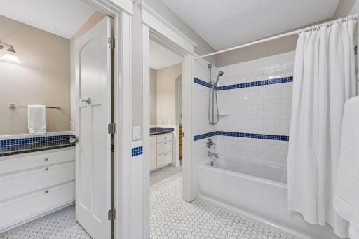 The ultimate shared bathroom design! This perspective from the shared tub and toilet area perfectly illustrates how the layout opens up to two completely separate, private vanity rooms, ensuring effortless and stress-free morning routines.