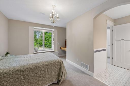 The perfect blend of charm and function! This third upper-level bedroom features a handmade built-in desk, a spacious walk-in closet, and an adorable window seat flanked by custom bookcases. It also enjoys its own private Jack & Jill vanity area.