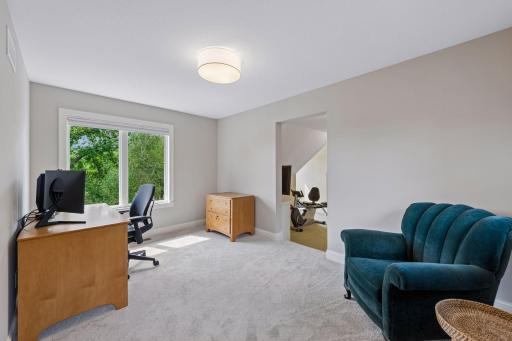 Imagine working or relaxing here! This open lofted bonus space offers a flexible layout perfect for a desk or cozy chairs, wrapped in natural light and scenic lake views.