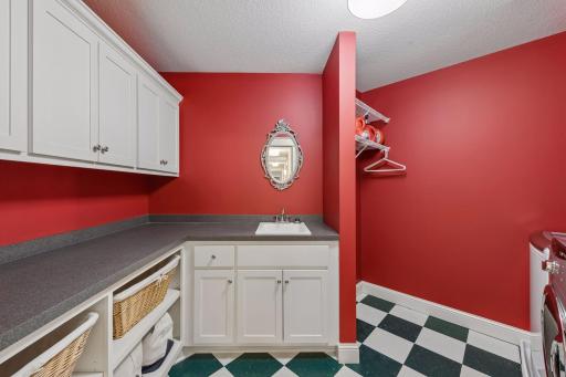 Ultimate convenience! Situated right by the bedrooms, this upper-level laundry room makes chores a breeze with a massive folding counter, extensive upper and lower cabinets, a washer and gas dryer, and a deep, practical utility sink.