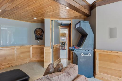 The ultimate flex space with a twist! This game zone includes beautiful knotty pine ceilings and wainscoting, recessed lighting, and surround sound. Best of all, a HIDDEN WALL DOOR that leads to the custom workshop & stairs to the main-level office.