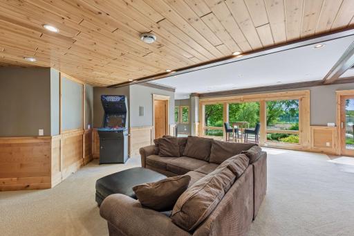 Bring the outdoors in! A striking wall of windows floods this expansive lower-level family room with beautiful natural light, offering continuous, breathtaking views of the professionally landscaped backyard and the pristine lake beyond.