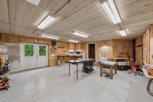 Seamless indoor-outdoor workflow! The workshop features wide double doors leading right to the backyard for moving large materials. It comes loaded with custom-built storage cabinets and drawers for organization, plus a handy utility sink.