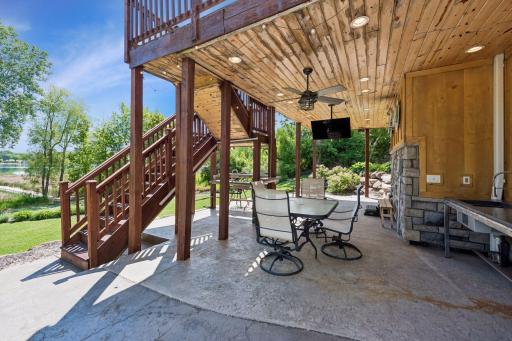 The ultimate outdoor hosting hub! Step out to a beautiful stamped concrete patio fully loaded for entertaining, featuring two working sinks, TV hookups, power, hot tub wiring, a built-in bar under the stairs, & a cozy knotty pine ceiling with fan.