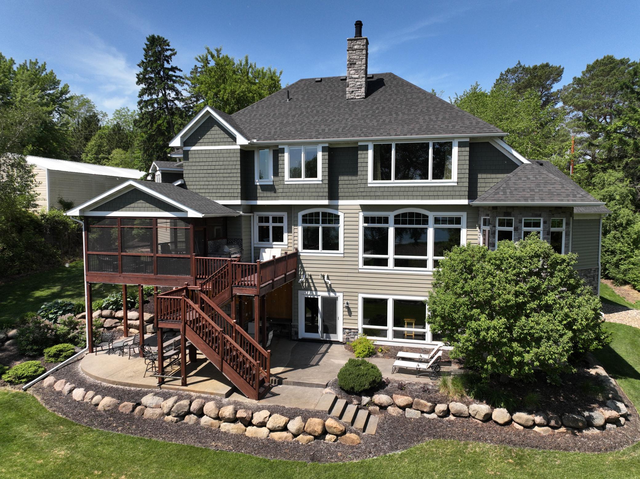 Another view of the professional landscaping and outdoor areas - screen porch, grill deck, and under-deck bar area with two sinks, TV & hot tub wiring.
