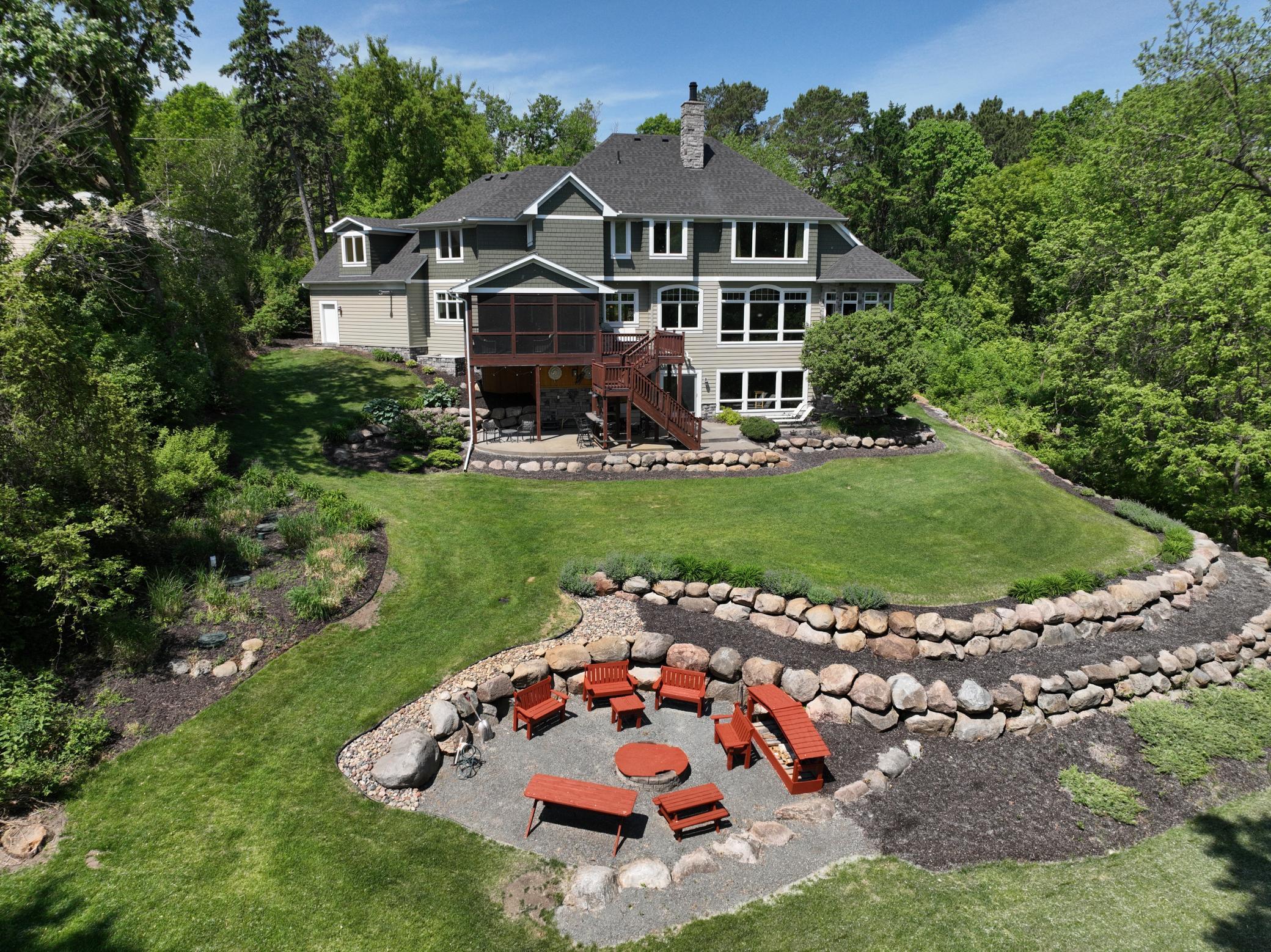 Experience outdoor perfection with professional tiered landscaping leading to a cozy fire pit area. complete with custom, handmade patio furniture. Your private lakeside retreat.