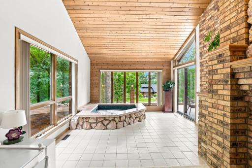 View of the built in hot tub surrounded by windows and a vaulted ceiling for ample natural light