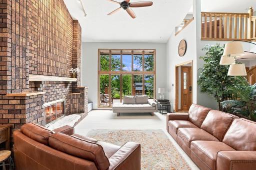 Living room with 14 foot vaulted ceilings and double sided gas burning fireplace