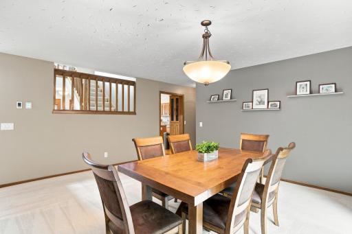 Dinning area with railing that looks at the stairs going to the upper level and the kitchen