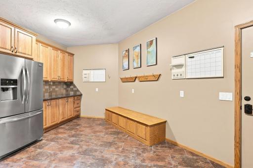 Entry way coming in from the garage with built in bench seating, storage and extra fridge not far from the kitchen!
