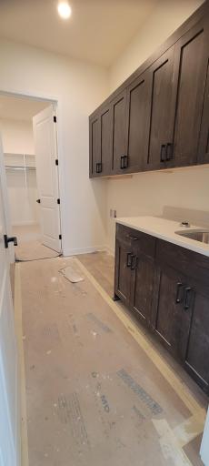 This beautiful and impressive laundry room on the main level offers an abundance of storage space for your everyday needs as well as ultimate convenience because of the pass-thru access into the primary suite closet, and a built-in utility sink!